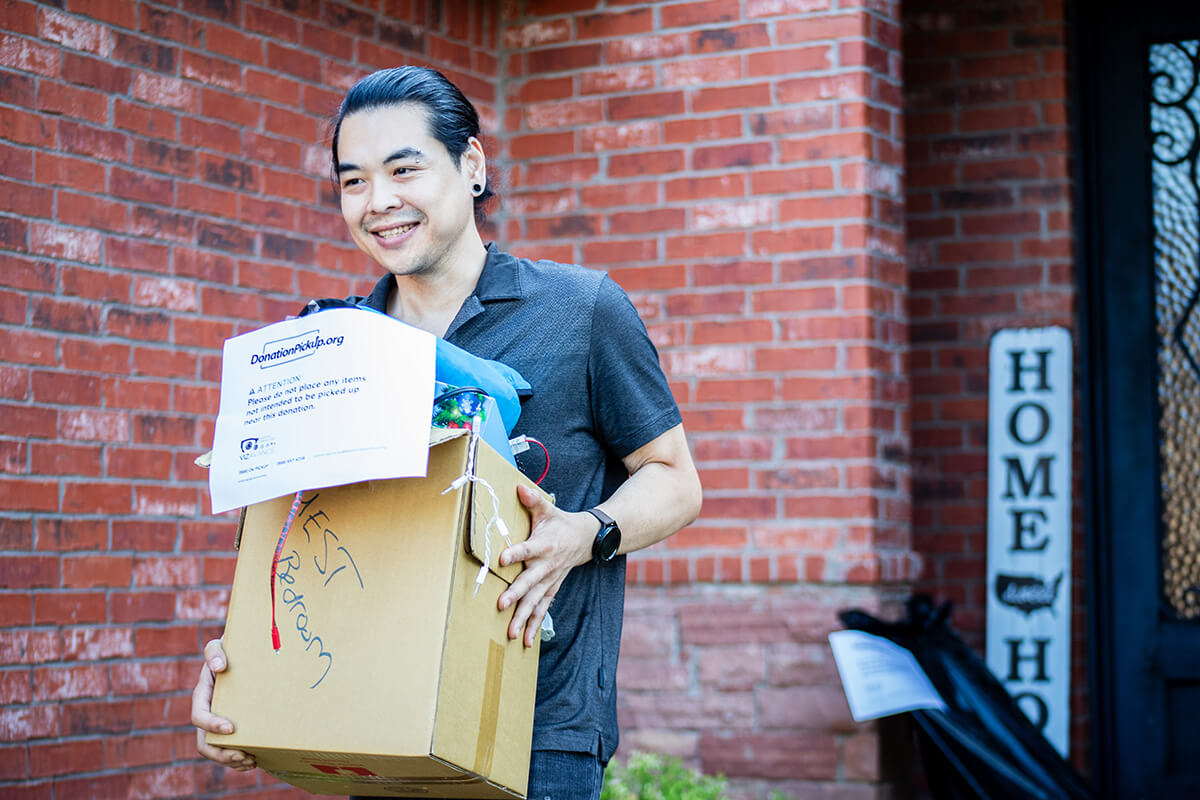 A donation pickup worker carrying a box