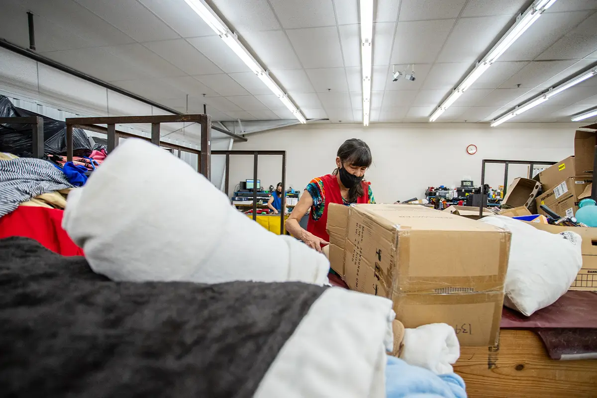 A woman at a donation center sorting through donations.